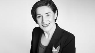 Czarnobiałem zdjęcie formalnie ubranej kobiety na jasnym tle